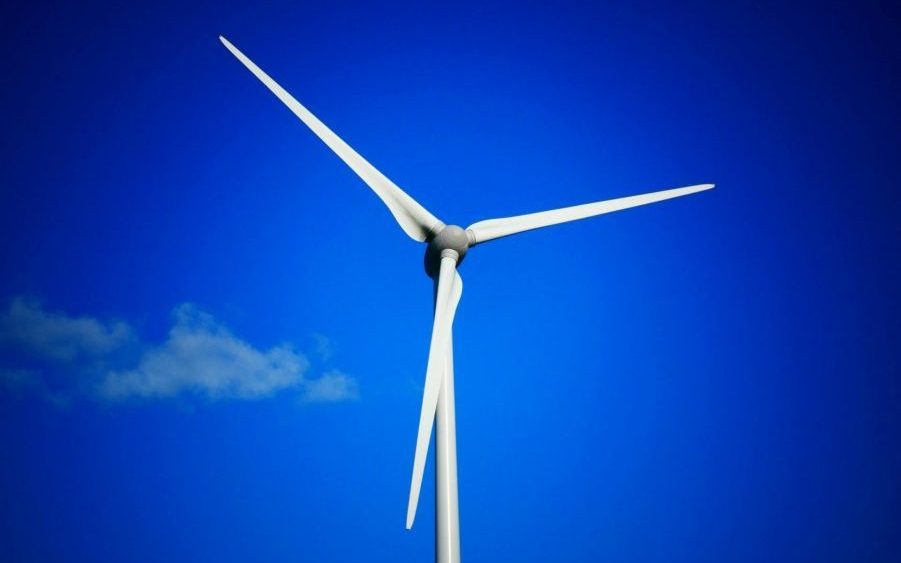 Wind turbines generating clean energy under a bright blue sky.